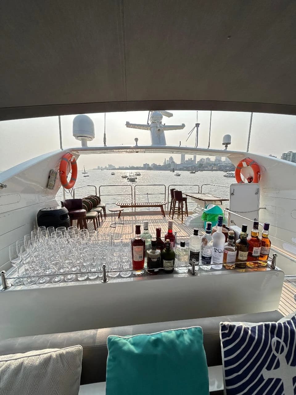 The flybridge wet bar stocked with glassware and spirits at golden hour