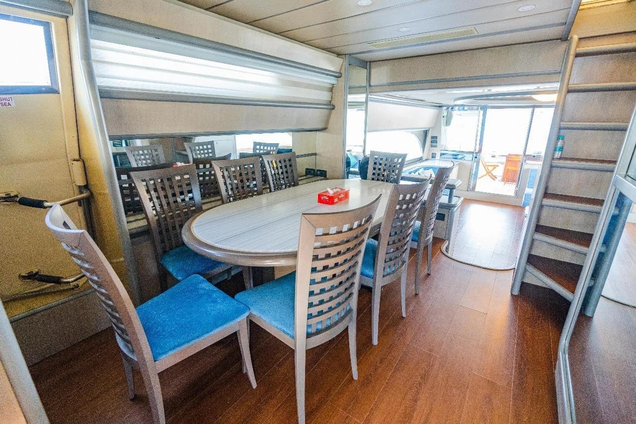The indoor formal dining table, seating eight, with the aft deck visible beyond