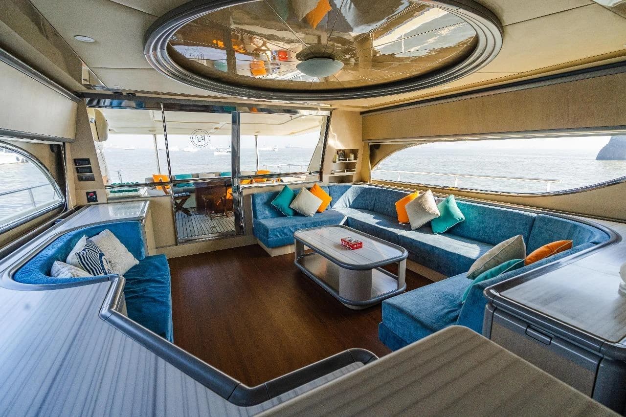 The saloon's modern blue lounge seating, looking toward the aft deck doors
