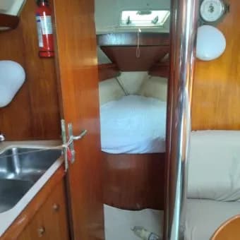 The forward cabin with a made-up berth, seen through the saloon doorway