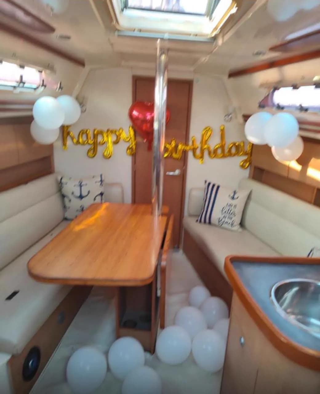 A happy birthday balloon display in the saloon with white balloons on the floor